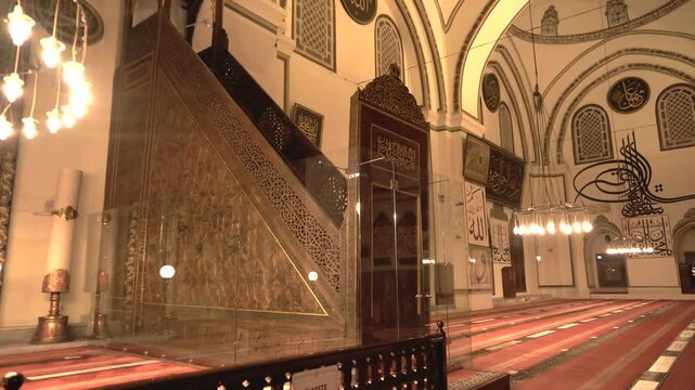 Turkey mosque mihrab and sermon platform glow at night inside a silent prayer hall.