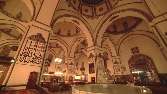 Turkey mosque fountain pool reflects warm night lights inside a quiet sacred interior.