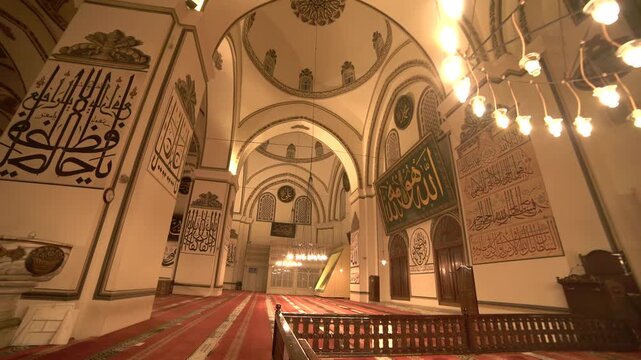 Turkey mosque mihrab and sermon platform glow at night inside a silent prayer hall.