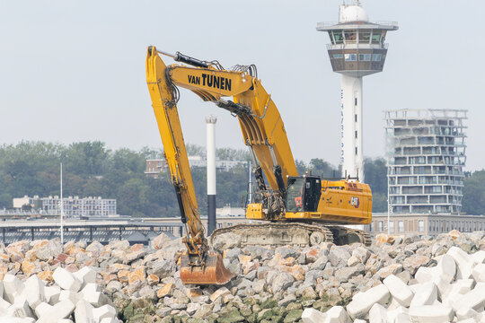 Le Havre, France - August 26th 2026 : View on a yellow long reach crawler excavator CAT 395 for earthworks to construct a new offshore breakwater.