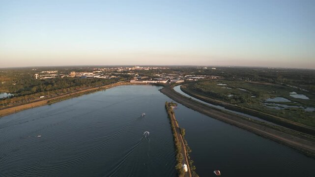 Massive river with boats near Mechelen, Belgium, surrounded by green landscape and city in the distance