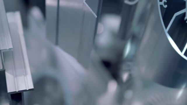 Samples of new aluminum industrial profiles of varying shapes and design complexity are presented at the exhibition. Closeup. Shot in motion