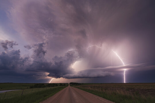 Supercell storm with Lightning over rural road at Dusk in nebraska