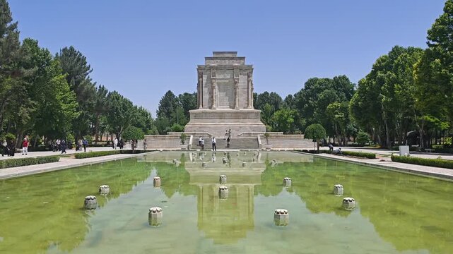 Ferdowsi Tomb and reflecting pool stand within a landscaped park in Iran in natural habitat.