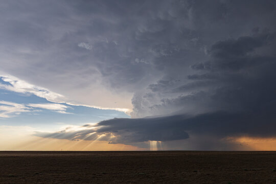 Developing Storm with sunlight rays over open plain
