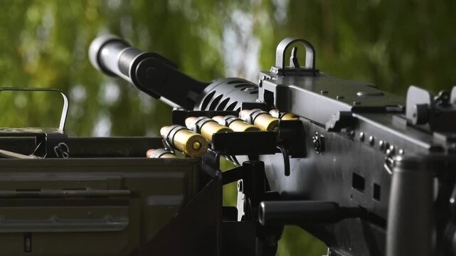Close-up view of a machine gun with loaded ammunition, prepared for combat use. Military equipment, armed conflict, battlefield readiness, and the Russo-Ukrainian War concept.