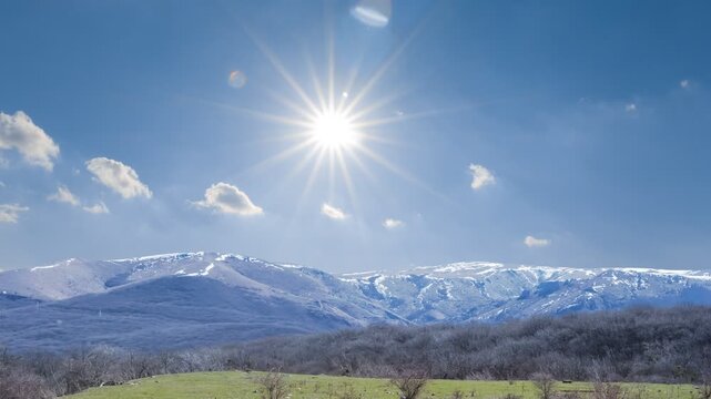 snowbound mountain ridge under a sparkle sun time lapse scene