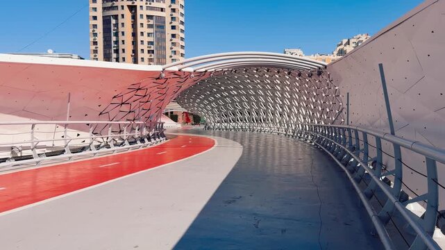 Atyrau Bridge in Astana, featuring curved white canopy, geometric metal panels, red pathway and modern architectural design, Kazakhstan, shot handheld, 4k footage