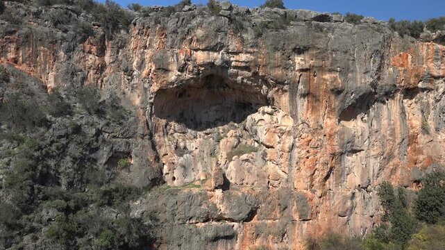 Large karst sinkhole reveals rocky walls deep depression with limestone geology rugged terrain.