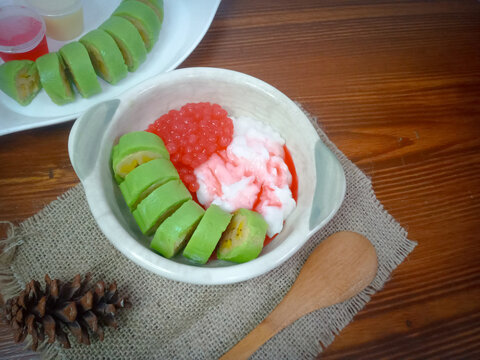 Es Pisang Ijo, traditional dessert from Makassar, South Sulawesi, Indonesia, made from banana which is rolled with a mixture of wheat flour, rice flour and coconut milk. Served with pureed and syrup.