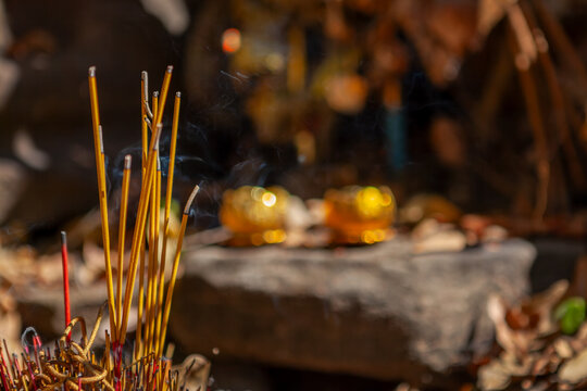 Close up of burning encense sticks and offerings in Prasat Beng Mealea, khmer temple, Angkor, Cambodia