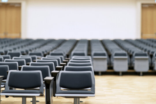 Defocused university lecture hall with rows of empty seats, education backdrop