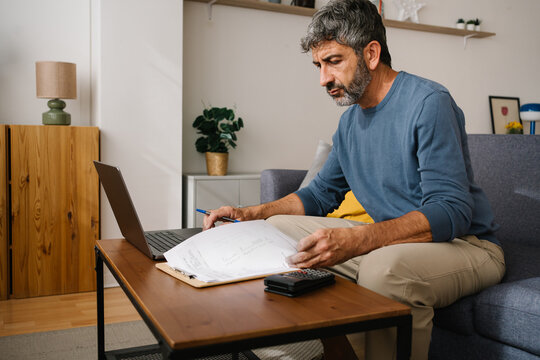 Man reviewing family household bills planning finances and domestic economy at home