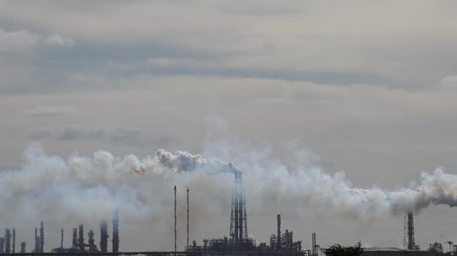 Air Pollution Concept - Industrial factory smokestacks billowing heavy smoke with sky background 4k Video footage