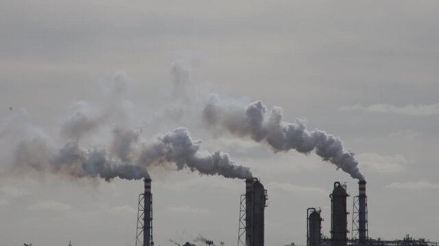 Industrial plant chimneys emitting heavy smoke and air pollution, concept of climate change, carbon emissions, and environmental degradation 4k Video footage