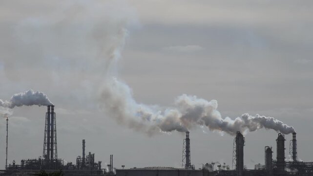 Air Pollution Concept - Industrial factory smokestacks billowing heavy smoke with sky background 4k Video footage