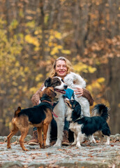 Fototapeta premium happy woman with dogs playing outdoors in autumn forest