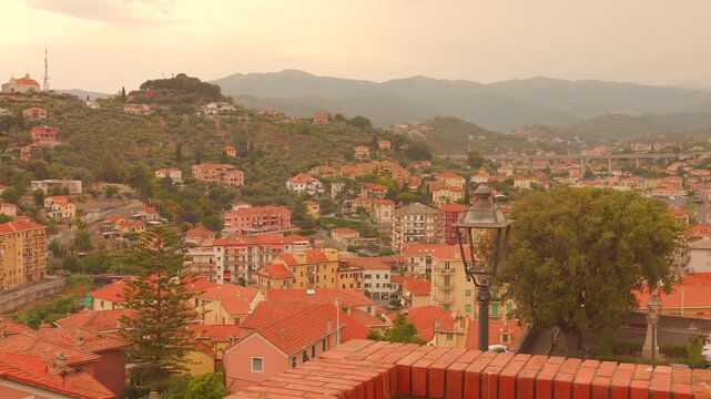 Wide view over Imperia rooftops and hills at sunset, Italian Riviera townscape