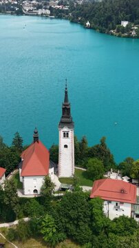 Vertical Drone Shot of Lake Bled and Virgin Mary Catholic Church on Small Island by Turquoise Alpine Water