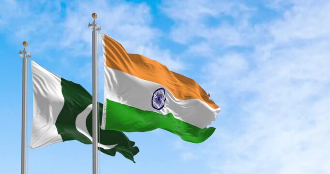 Pakistan and India national flags waving on a clear day