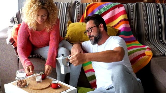 A happy couple enjoys a relaxing coffee moment at home, sharing smiles and a peaceful morning together, a cozy start to their day in comfortable loungewear.