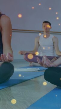 Vertical video: Camera framing hands, yoga group holding mudra on mats, sparkles enhancing calm