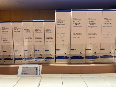 A row of neatly packaged boxes displayed on a shelf. Each box is light brown with blue accents. The setup suggests a product line or brand. Simple and organized arrangement.