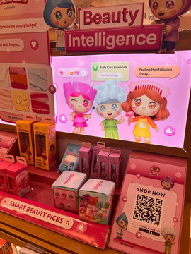 A colorful display in a retail store showcasing toy products. The scene features animated character dolls with vibrant hair. Various beauty items are arranged in pink packaging.