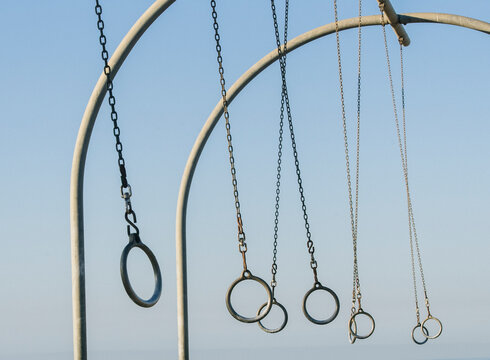 Gymnastic rings hanging outdoors against blue sky
