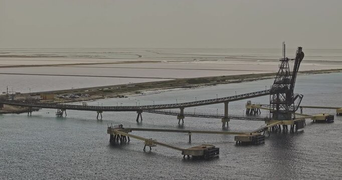 Bonaire Caribbean Netherlands Aerial v48 zoomed fly around Pier 49 capturing Cargill Salt Works' production facility, pink evaporation ponds and salt pans - Shot with 5k Camera - Feb 3rd 2024