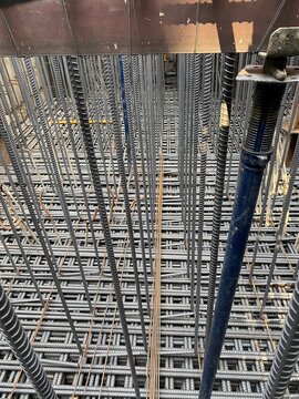 Steel reinforcement and temporary supports at an urban construction site in Silom, Bangkok, Thailand.