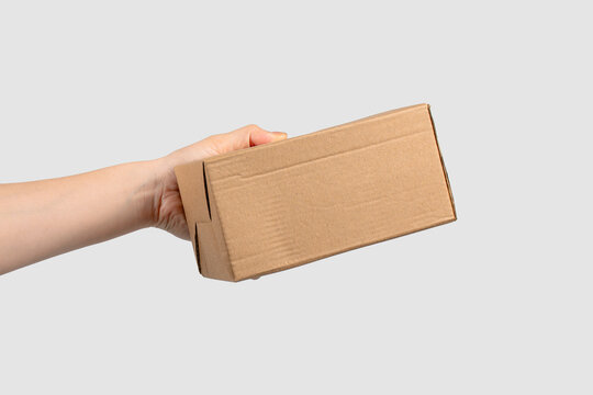 Light brown cardboard box, packaging box for items in hand, white background.