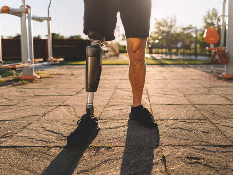 Close-up of a mature man with a prosthetic leg standing at an outdoor gym