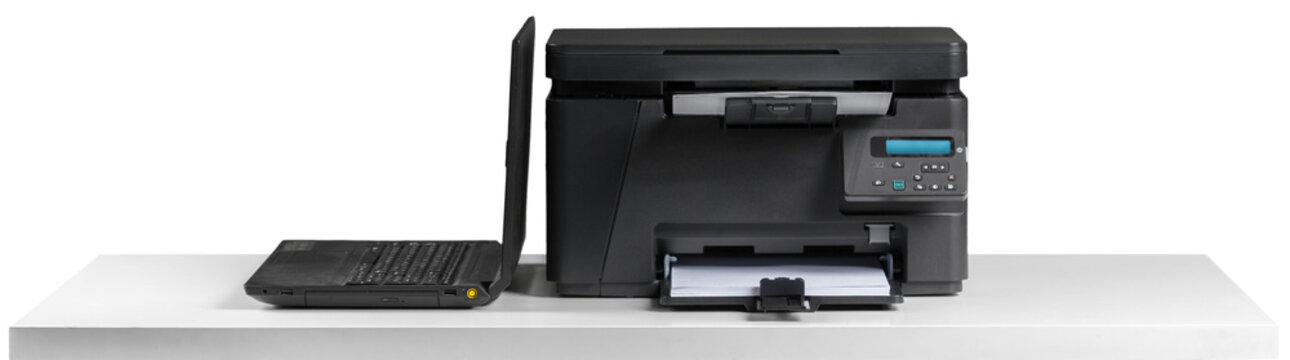 Printer and laptop on a desk in a home office setting
