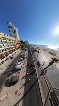 TEL AVIV, ISRAEL - SEPTEMBER 21, 2026: Aerial view of empty Herbert Samuel Street and promenade during Yom Kippur with cyclists riding bicycles.