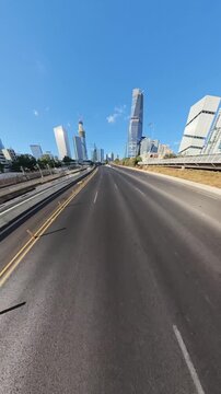 TEL AVIV, ISRAEL - SEPTEMBER 21, 2026: Low drone shot passing under bridge revealing empty Ayalon Highway and skyscrapers during Yom Kippur.