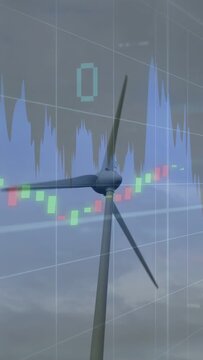 Vertical video: Wind turbine rotating by wind, finance overlay animating to show energy market data