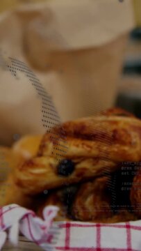 Vertical video: Slow pan showing glazed pastry stack, bag and fruit on red towel, selling pastries