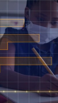 Vertical video: Masked girl placing pencil on pad writing for class as orange overlay crossing page