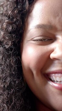 Vertical video: Woman smiling, smile causing AR green circle drifting across cheek for wellness
