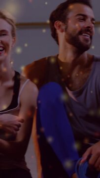 Vertical video: Yoga group with blue mats laughing, smiling in joy as camera panning, golden bokeh