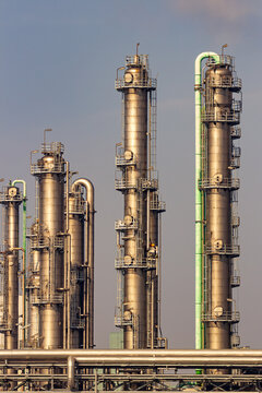 Pipes, pipelines and cooling towers at an industrial oil refinery and power station as part of the energy production infrastructure.