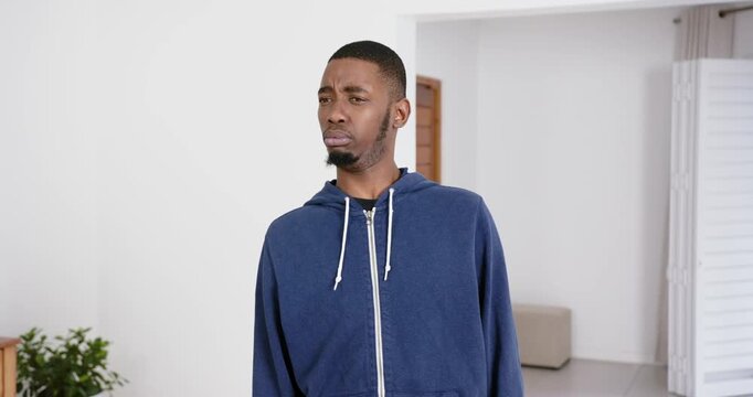 High speed photography for dynamic scenes, man in blue hoodie making confused expression in bright i