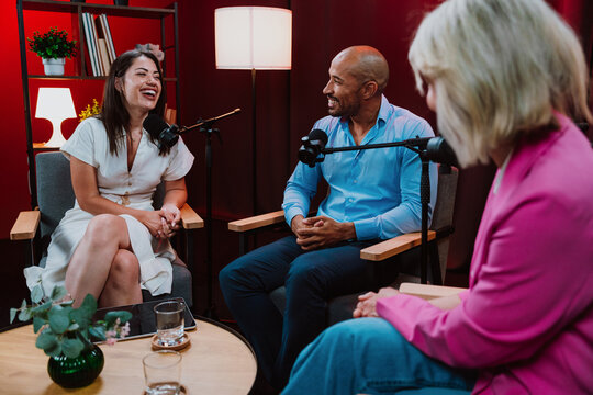 Content creators broadcasting live podcast interview using microphones