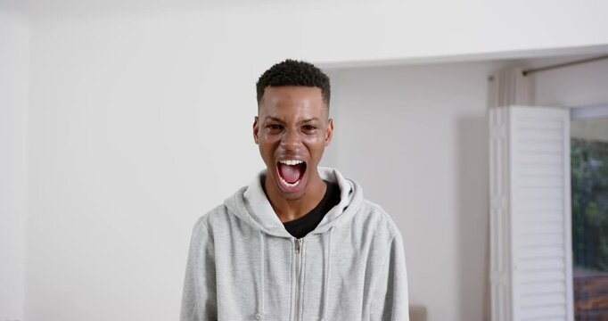 High speed photography for dynamic scenes, shouting loudly, man in gray hoodie expressing intense em