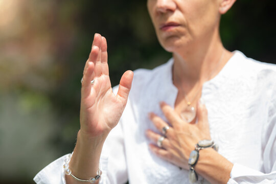 Alignment: mindfulness coach holding one hand over heart and one hand forward, expressing emotional balance, inner focus and spiritual awareness.