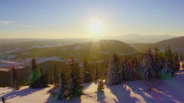 An extraordinary valley with hills and mountains covered with fir forests against the backdrop of a bright fiery sunset