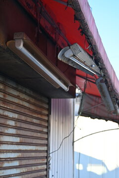 古びたシャッターと蛍光灯のある店舗の外観