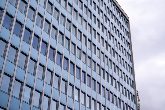 Modern office facade with repeated windows and strong perspective, showing geometric architecture through a grid pattern across the modern office facade