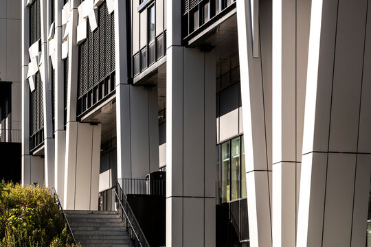 Modern building entrance with steps and vertical columns, showing contemporary architecture around the facade and entrance with columns defining access